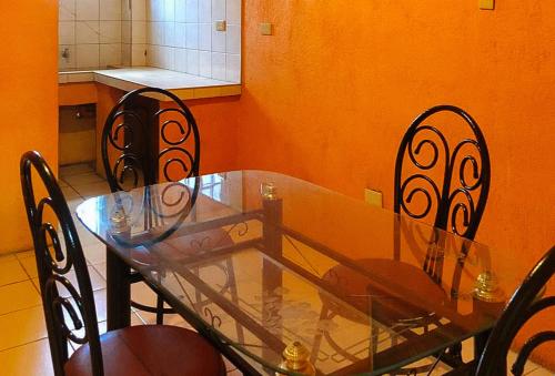 un tavolo in vetro e sedie in cucina di Maro Bianco's Inn Lubao Pampanga by RedDoorz a Lubao
