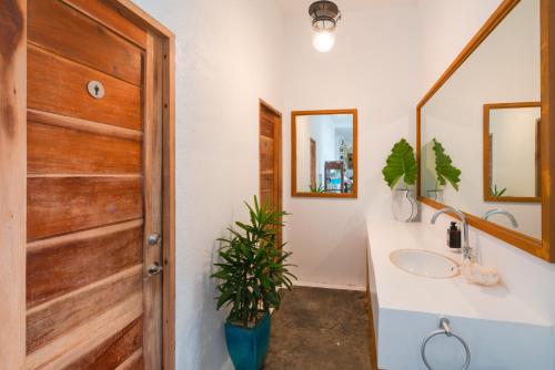 baño con lavabo y puerta de madera en Hop Hostel en Corón