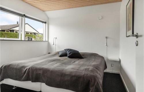 2 Bedroom Nice Home In Kerteminde في كيرتيمايند: غرفة نوم بسرير كبير مع نافذة كبيرة