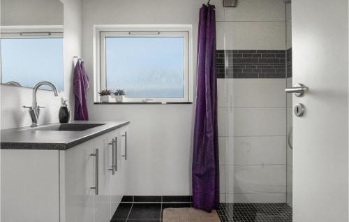 bagno con lavandino e doccia con tende viola di 2 Bedroom Nice Home In Kerteminde a Kerteminde
