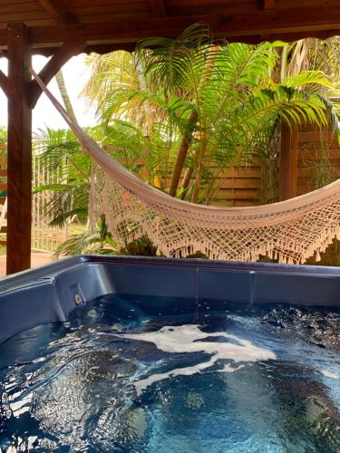 a hot tub in a hammock in a garden at Nid Kreyol in Sainte-Anne