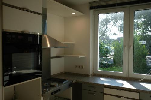 cocina con ventana grande y fogones horno superior en Ruhiges Haus mit privatem Garten, en Halstenbek