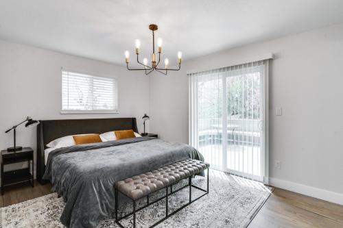 a bedroom with a large bed and a chandelier at @ Marbella - Spacious and Modern Home in Arvada in Arvada