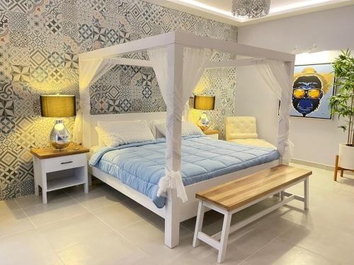 a bedroom with a white canopy bed and a table at Hotel Mono Azul in Quepos
