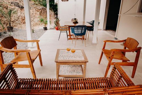 a patio with wooden chairs and a table and a tableablish at Nid Kreyol in Sainte-Anne
