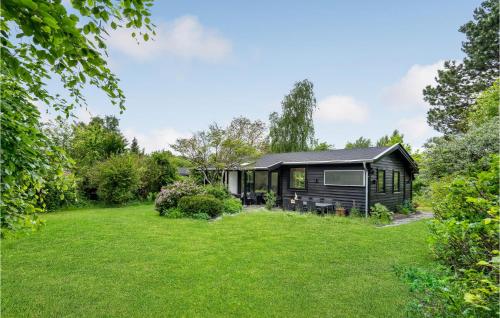 a black cabin in the middle of a yard at 2 Bedroom Cozy Home In Dronningmølle in Dronningmølle