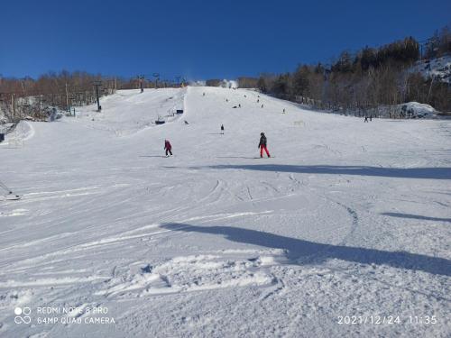 un groupe de personnes skier sur une piste enneigée dans l'établissement luxurious Mont tremblant 2bd 2bth, à Mont-Tremblant