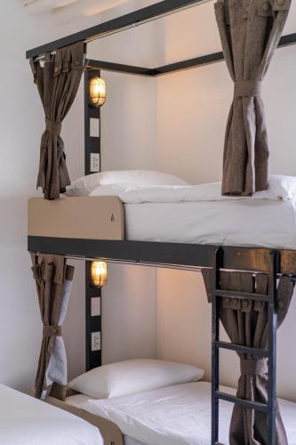 two bunk beds in a dorm room with lights at Hop Hostel in Coron
