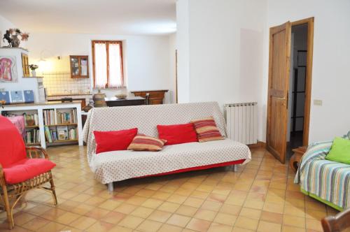 a living room with a white couch with red pillows at Camere Sotto le Stelle in Umbertide