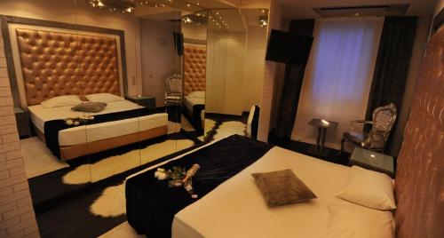 a hotel room with two beds and a mirror at Carol Hotel in Piraeus