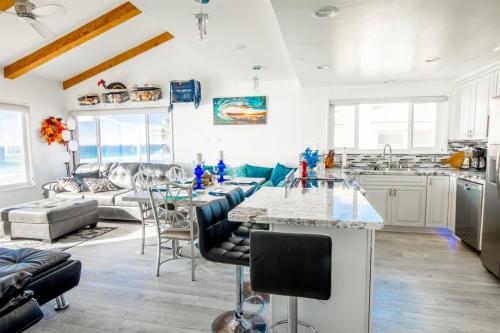 a kitchen and living room with a table and chairs at 120-oceanfront Penthouse 5 in San Diego