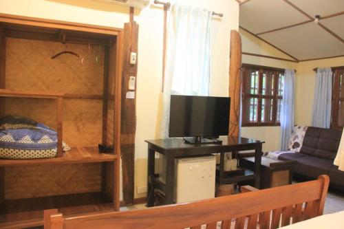 a living room with a television and a couch at Aerie Lodge in Pang Mapha