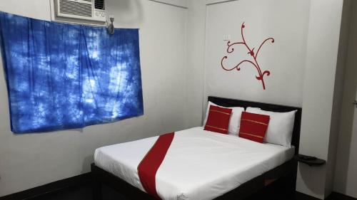 a bedroom with a bed with red pillows and a window at Regal Residences in Manila