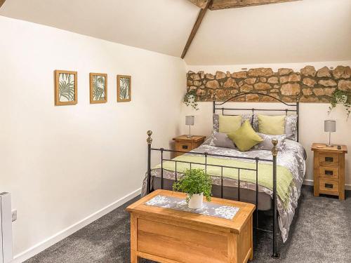 a bedroom with a bed and a wooden table at The Old Dairy Annexe in Donyatt