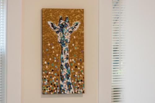 a painting of a giraffe hanging on a wall at Skyrise Two Stories - Centrally Located in Brookline