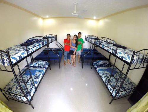 a group of three children standing in a room with bunk beds at Lambug Beach Homestay in Lambug