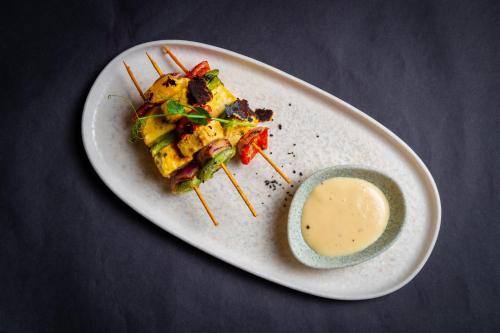 a white plate with a piece of food and a sauce at Crowne Plaza Nairobi Airport by IHG in Nairobi