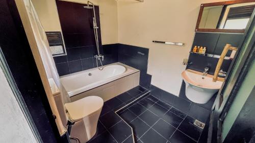 a bathroom with a tub and a toilet and a sink at Train View Chalet in Bandarawela