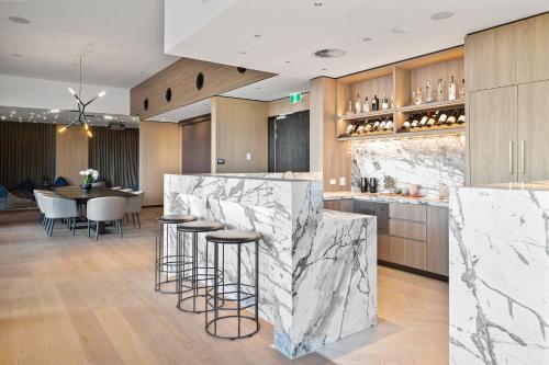 a kitchen with marble countertops and a table with stools at CASSA ONE - Luxury Apartments Managed by The Cassa in Brisbane