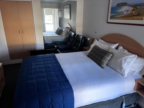 a bedroom with a large bed and a living room at The Dannebrog Lodge in Devonport
