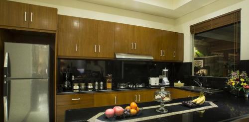 a kitchen with wooden cabinets and a counter with fruit on it at The oasis retreat seminyak in Seminyak