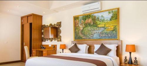 a bedroom with a bed and a painting on the wall at The oasis retreat seminyak in Seminyak