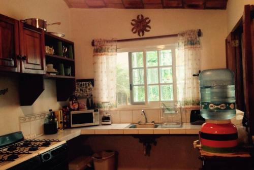 een keuken met een wastafel, een raam en een aanrecht bij Bungalow Casa de los Abuelos in Lo de Marcos