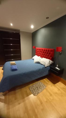 a bedroom with a large bed with a red headboard at Casa de campo in Belén