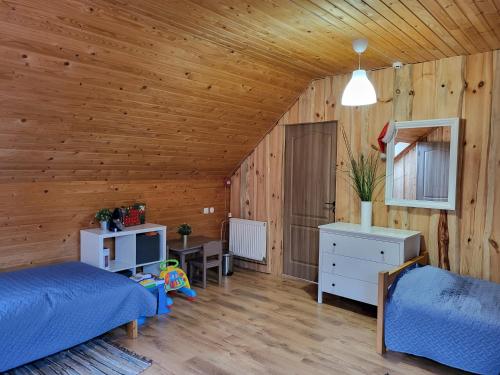 una camera da letto con pareti in legno, un letto e una TV di Vēverkalni a Vidriži
