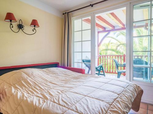 a bedroom with a bed and a view of a balcony at Appartement Ciboure, 2 pièces, 4 personnes - FR-1-4-480 in Ciboure