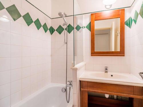 une salle de bain avec un lavabo, une baignoire et un miroir dans l'établissement Appartement Coquet avec Piscine et Balcon à Ciboure, Proche Golf de la Nivelle - FR-1-4-480, à Ciboure