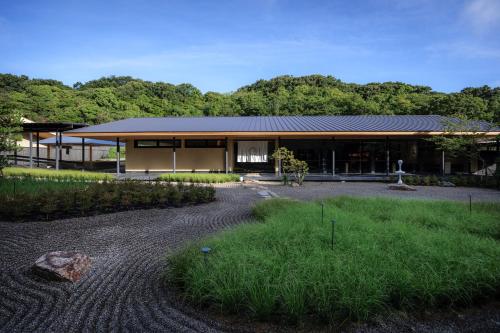 a house with a gravel driveway in front of it at Naoshima Ryokan Roka in Naoshima