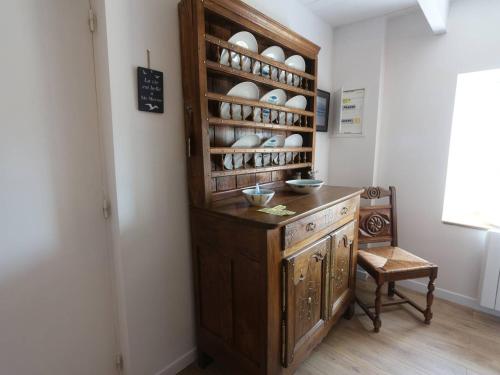 a kitchen with a wooden cabinet with dishes on it at Combrit Sainte-Marine: T2 duplex rénové avec jardin privé et vue sur port - FR-1-481-91 in Combrit