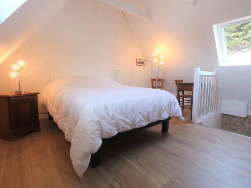 a bedroom with a bed and a table and a window at Combrit Sainte-Marine: T2 duplex rénové avec jardin privé et vue sur port - FR-1-481-91 in Combrit