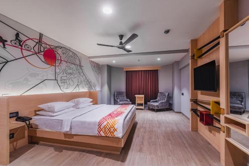 een slaapkamer met een bed en een flatscreen-tv bij Ginger Bharuch in Bharuch