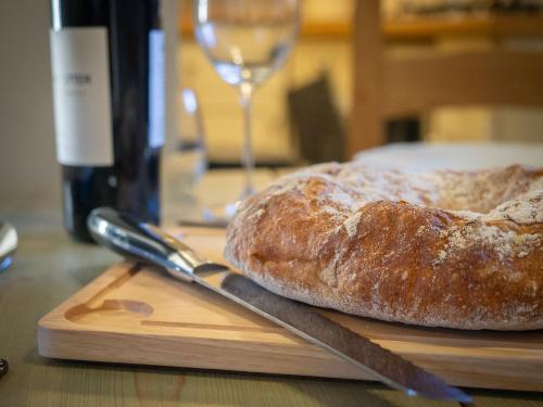 a loaf of bread sitting on a cutting board with a knife at The Beeches - Chatsworth Apartment No 1 - Sleeps 2 in Baslow