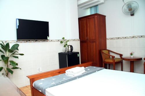 een slaapkamer met een bed en een flatscreen-tv bij HOTEL NGUYEN ANH in Ho Chi Minh-stad