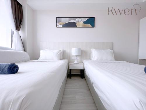 two beds sitting next to each other in a room at KWEN Suites-Tanjung Aru InfinityPool Seaview/Airport View in Kota Kinabalu