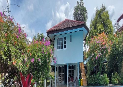 a small blue house with trees and flowers at YoskY Indonesia in Bogor