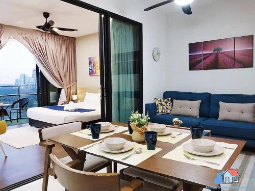 - un salon avec une table et un canapé bleu dans l'établissement Almas Suites @ Puteri Harbour, à Nusajaya