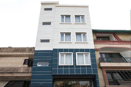 un alto edificio bianco e blu con finestre di SilverKey M&m Residency a Nuova Delhi