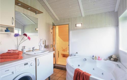 ein Badezimmer mit einer Badewanne, einem Waschbecken und einer Waschmaschine in der Unterkunft Schmugglerstieg 7 - Dorf 6 in Travemünde