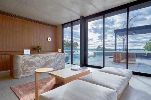 a living room with a couch and large windows at Wonil Hotel Perth - Handwritten Collection in Perth