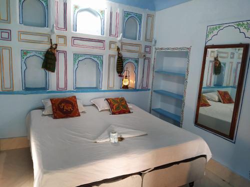 um quarto com uma cama grande e um espelho em Hotel Bharatpur Palace em Pushkar