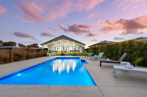 a swimming pool in the backyard of a house at Rio Vista - Luxury Accommodation in Rye