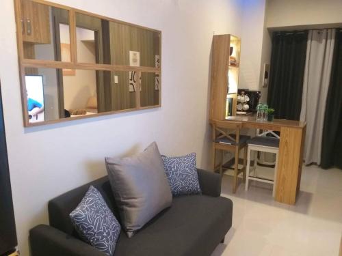 a living room with a couch and a mirror at Condo in Pasay in Manila