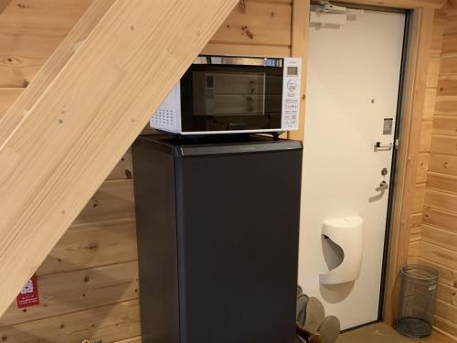 a microwave sitting on top of a refrigerator in a room at 安曇野遊人Ｃ.Ｌ.Ｊ.クラブ in Azumino