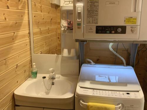 uma pequena casa de banho com um lavatório e um micro-ondas em 安曇野遊人Ｃ.Ｌ.Ｊ.クラブ em Azumino
