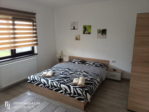 a bedroom with a bed with zebra print sheets at Casa Gabriela in Topliţa