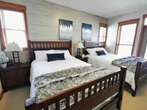 1 Schlafzimmer mit 2 Betten und 2 Fenstern in der Unterkunft Snowy Trails Lodge in Big White in Big White